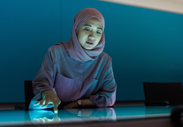 A student looks down at a large screen