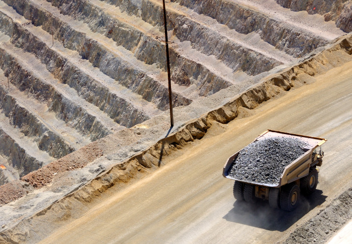 Digger breaking rocks at lithium mine