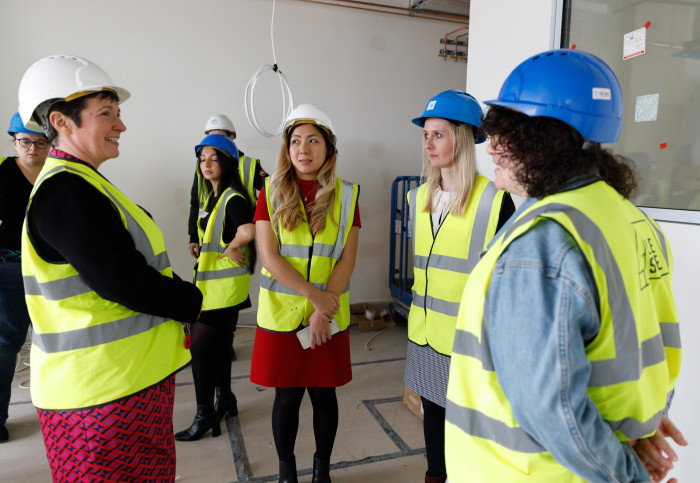 people in hard hats view incubator space