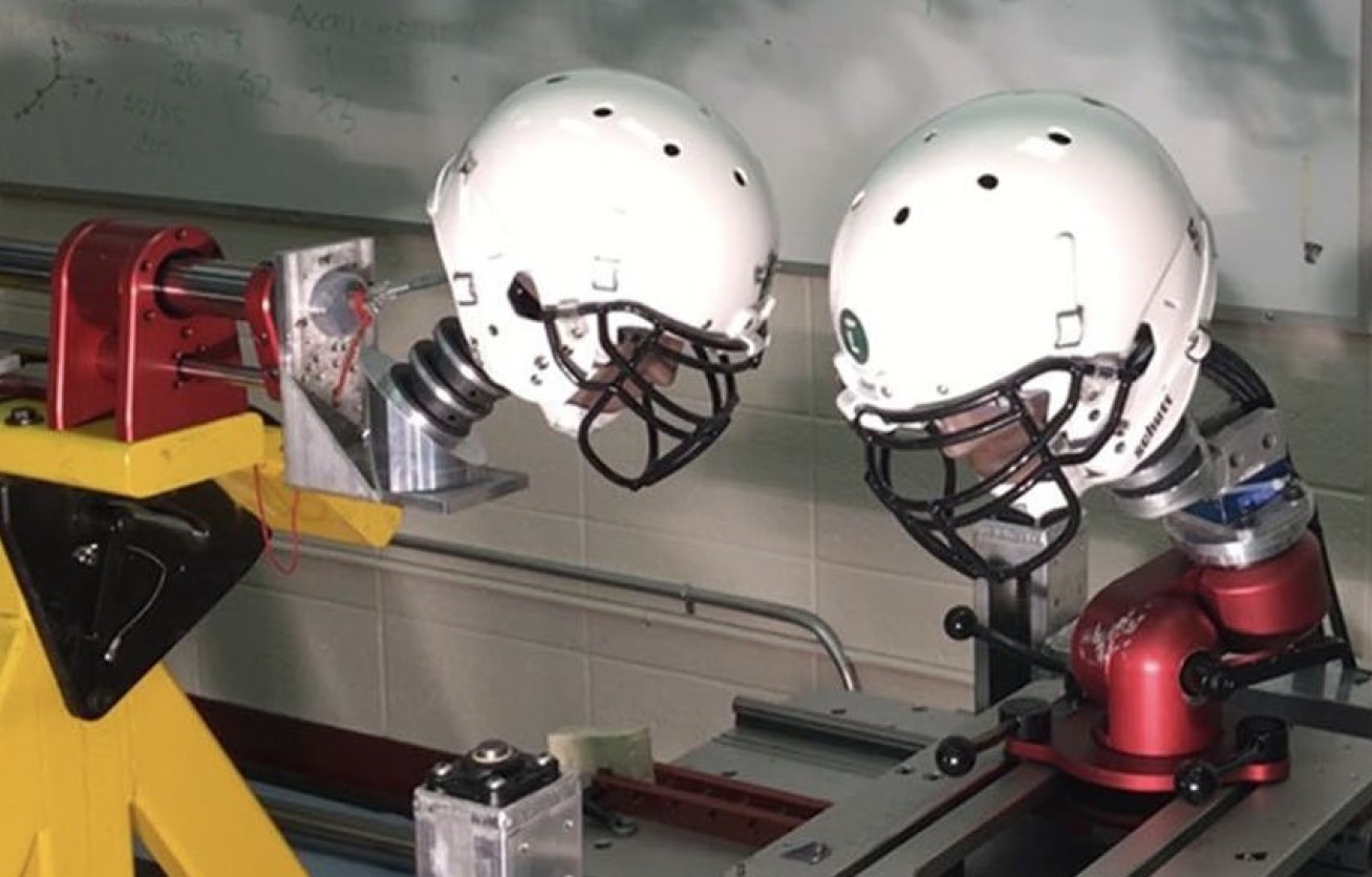 Picture of mechanical arms with dummy heads fitted onto the ends with american football helmets covering the heads.