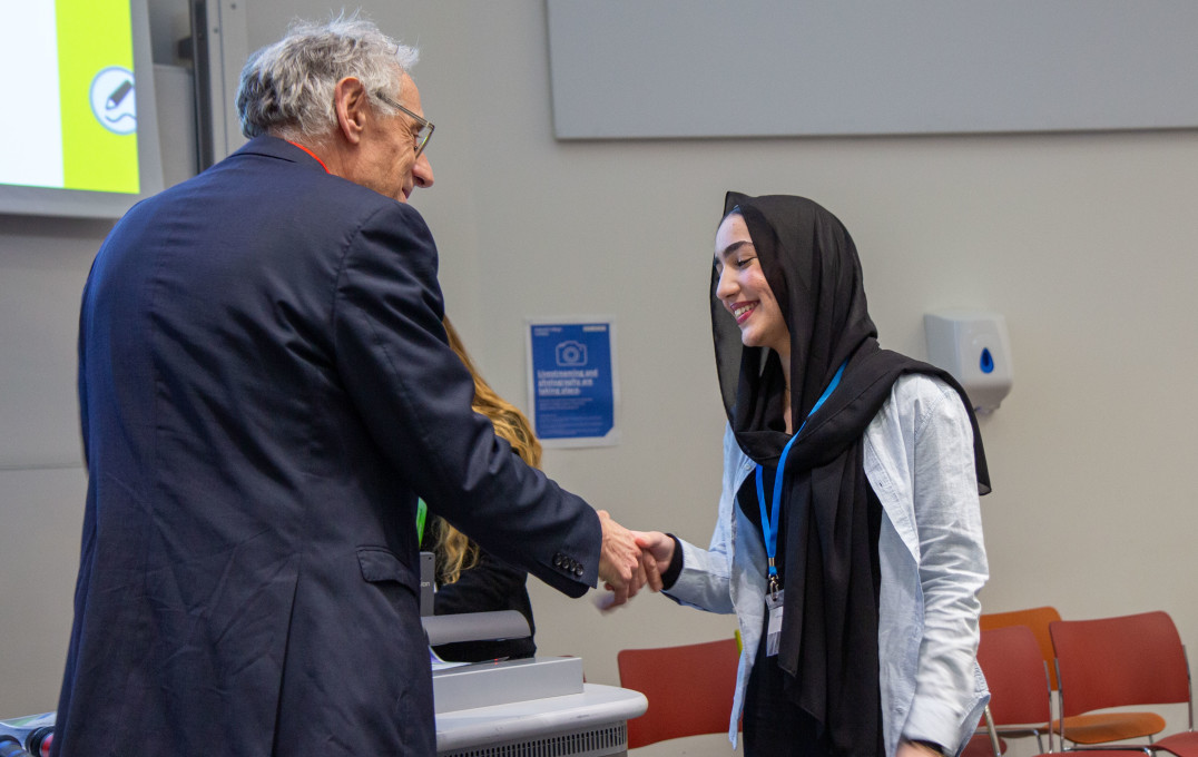 Professor Paul Elliott presenting an award to a student from Hammersmith Academy