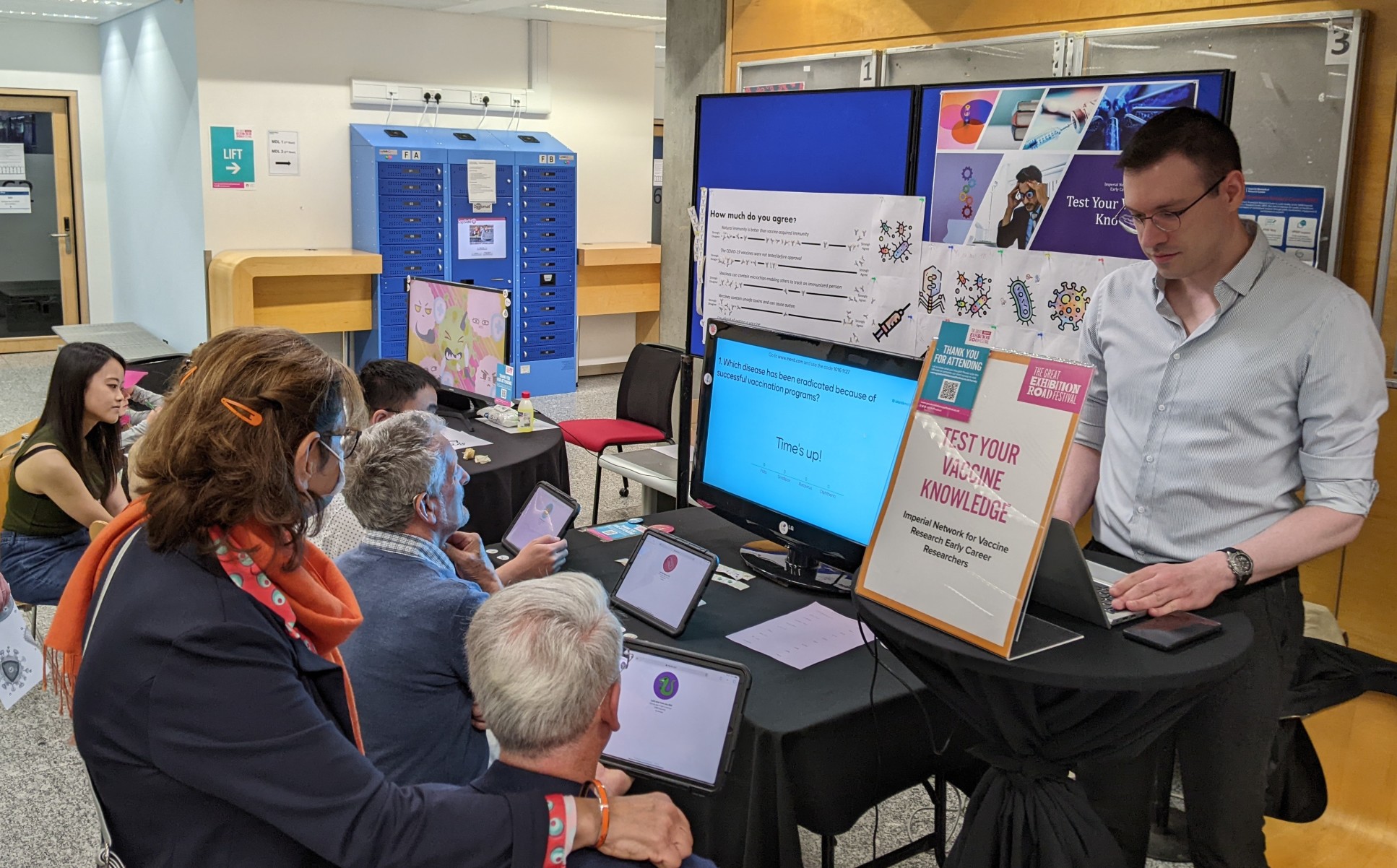 Five festival visitors taking a digital quiz testing their vaccine knowledge