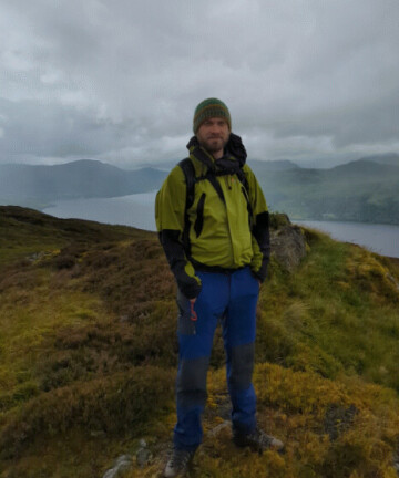Dr Tamlyn Peel, standing on a windy Scottish hill in the mizzle