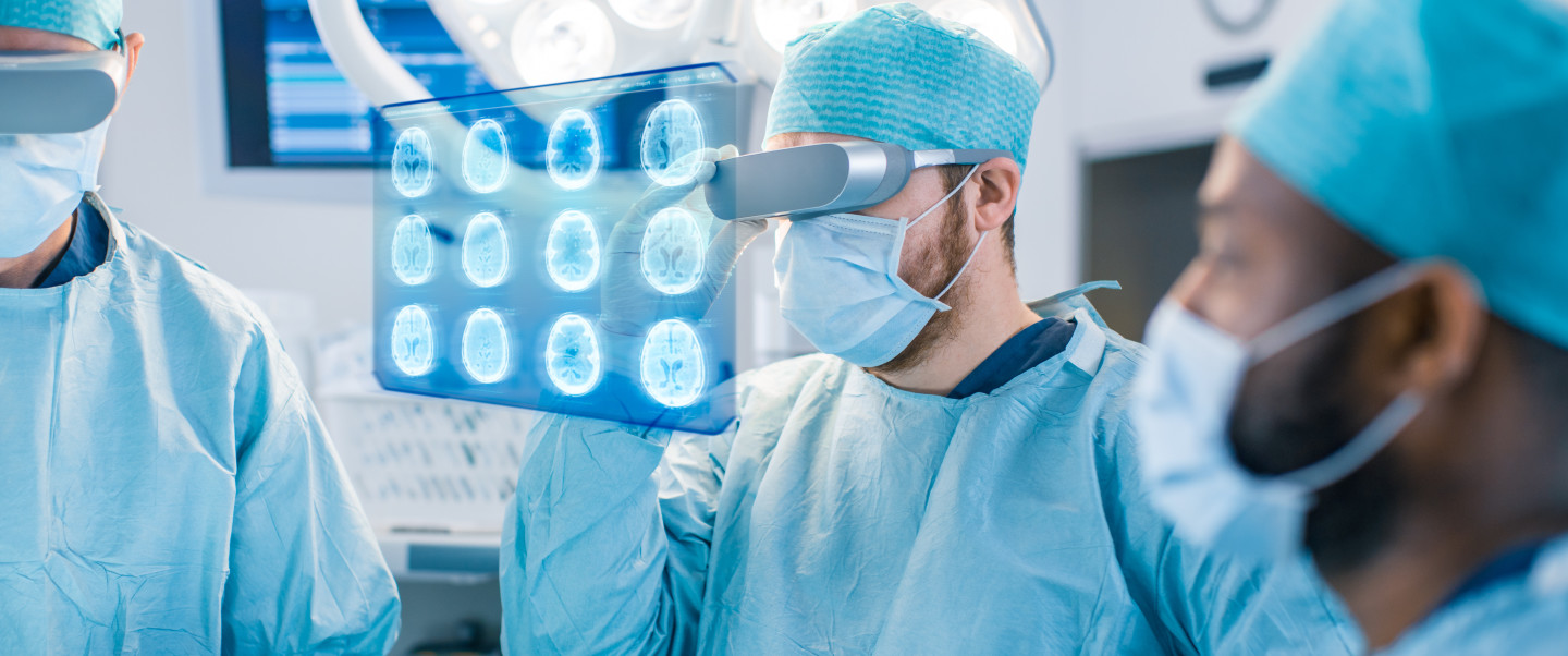 Surgeons wearing scrubs, hats and face masks use virtual reality headset 