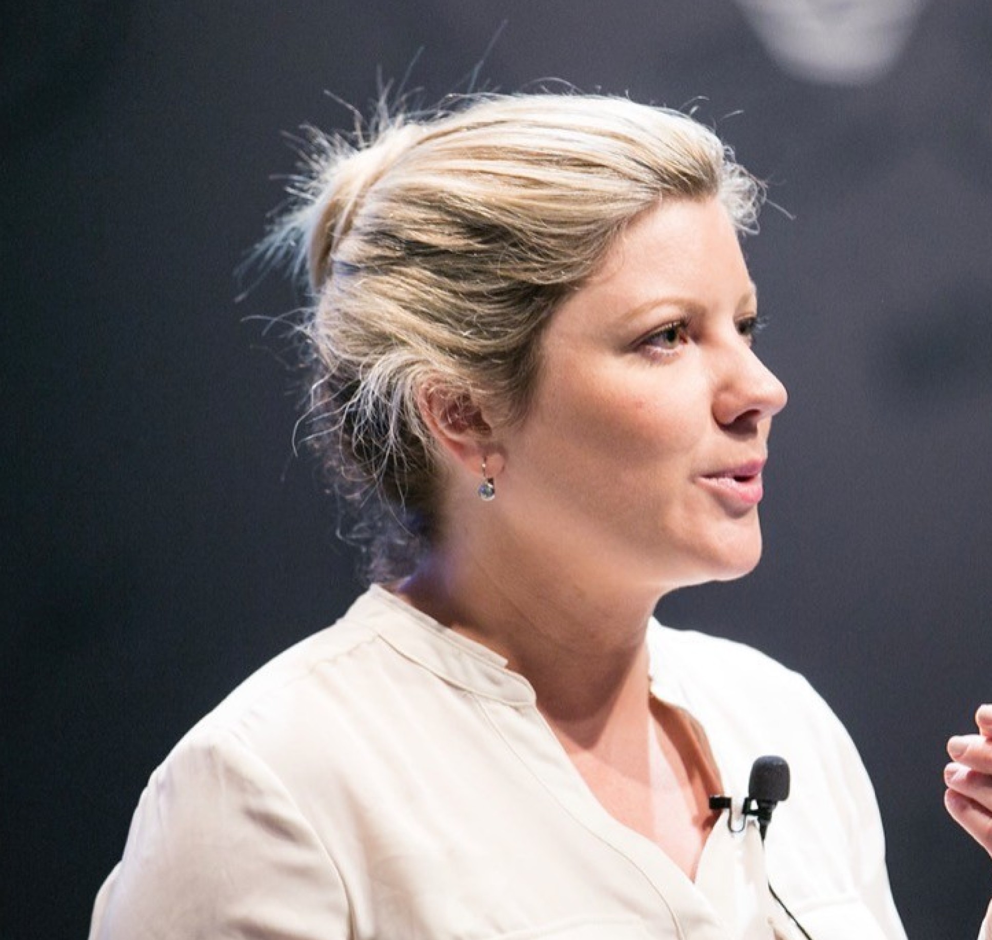 Side profile of white woman wearing blouse and clip microphone