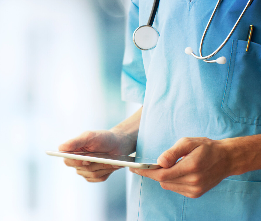 A doctor consulting their notes on a tablet computer