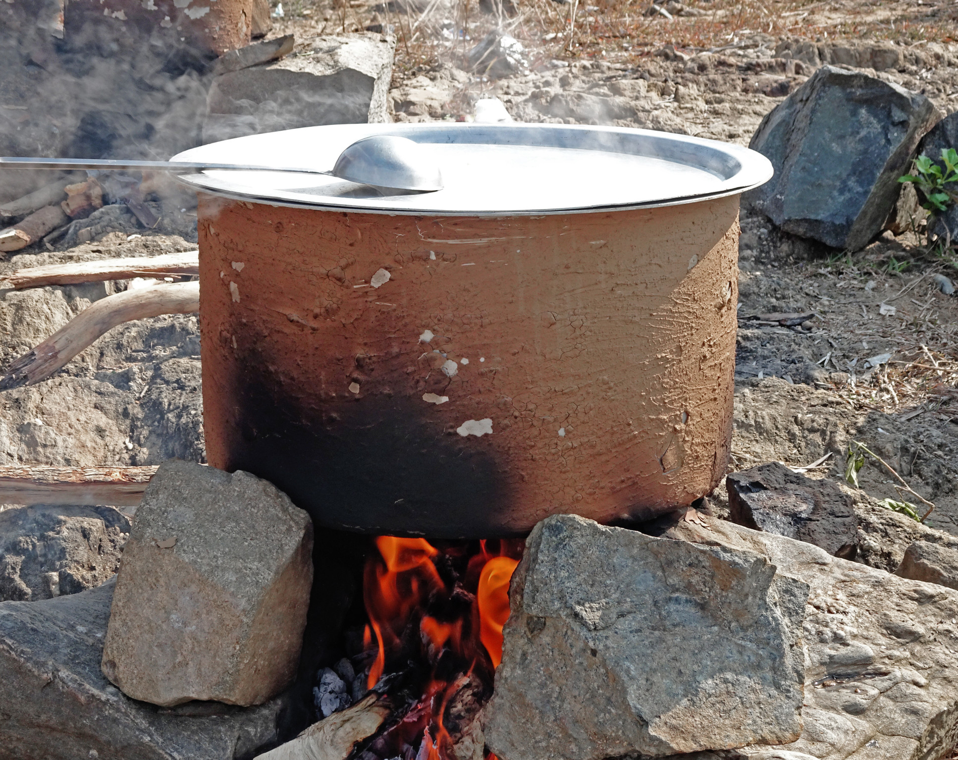 Cooking a pot over firewood and stones