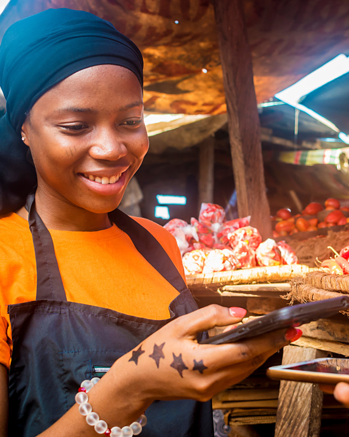 Woman in market taking payment by phone