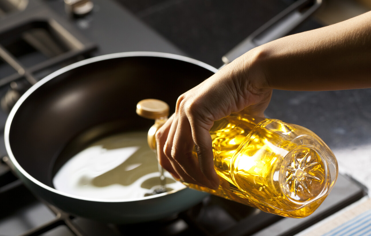 A person pours cooking oil into a pot