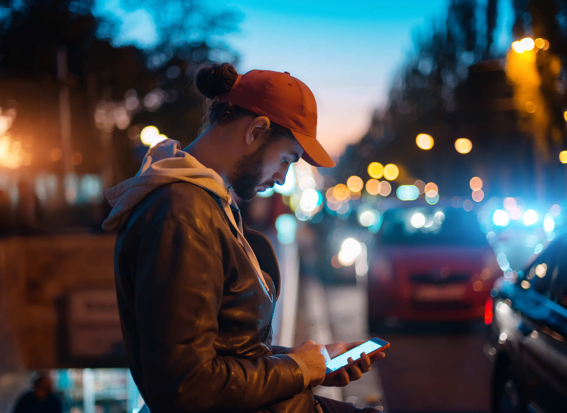 Man using phone in city at night