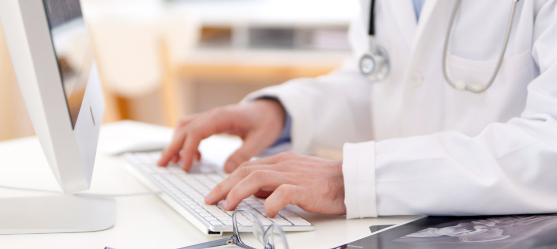 doctor writing up notes on a computer