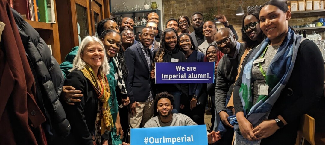 A group of alumni and Imperial staff who are active members of the Imperial black alumni network. They are pictured in a restaurant gathered for the photo, smiling with a couple of banners held up that read: 'We are Imperial alumni.' and '#OurImperial'