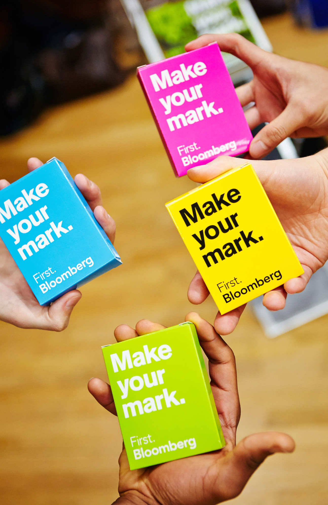 hands holding out colorful bloomberg promotional items
