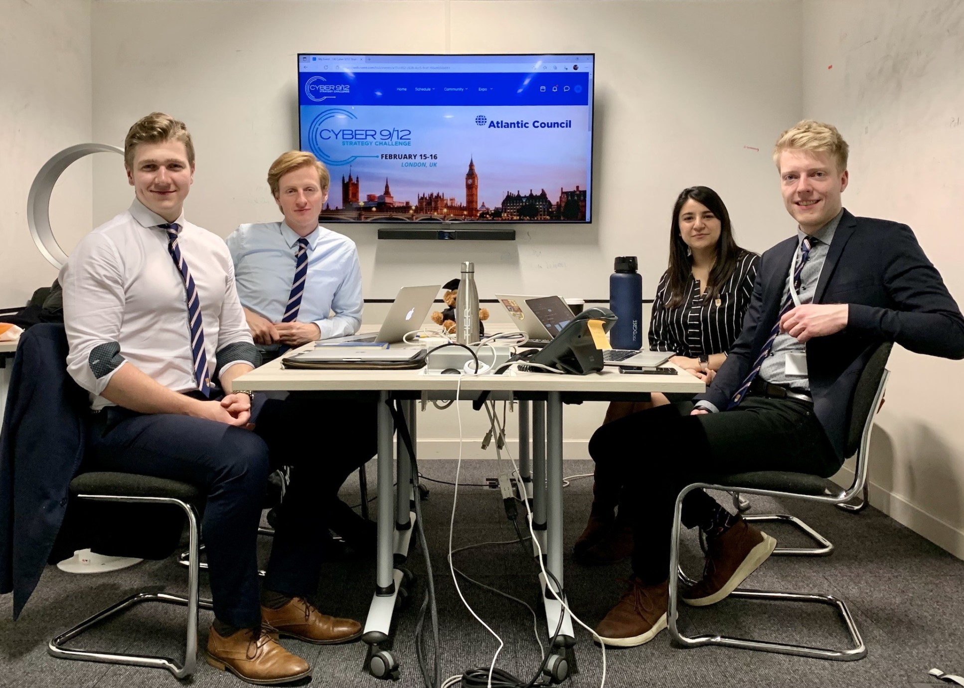 Four students sit at a conference table