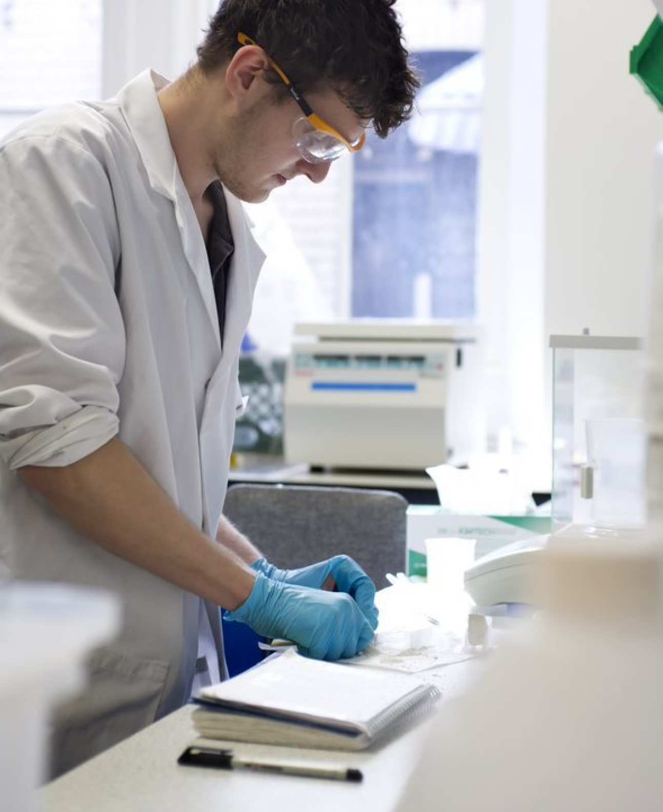 scientist with safety goggles and gloves in the lab