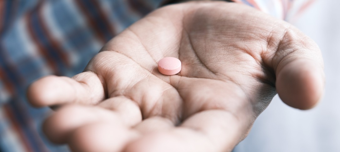 person holding one pink pill