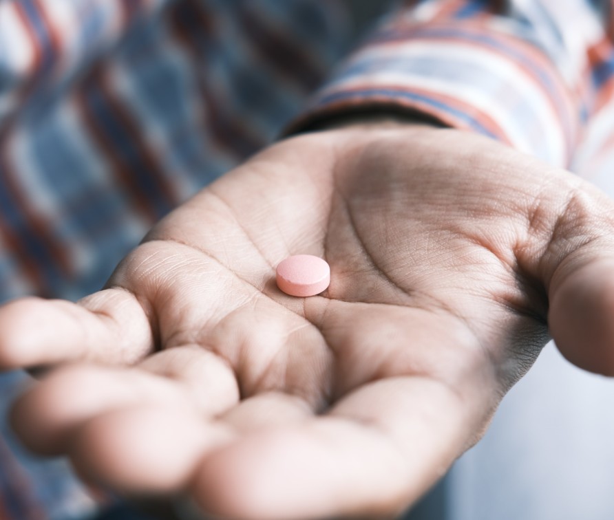 person holding one pink pill