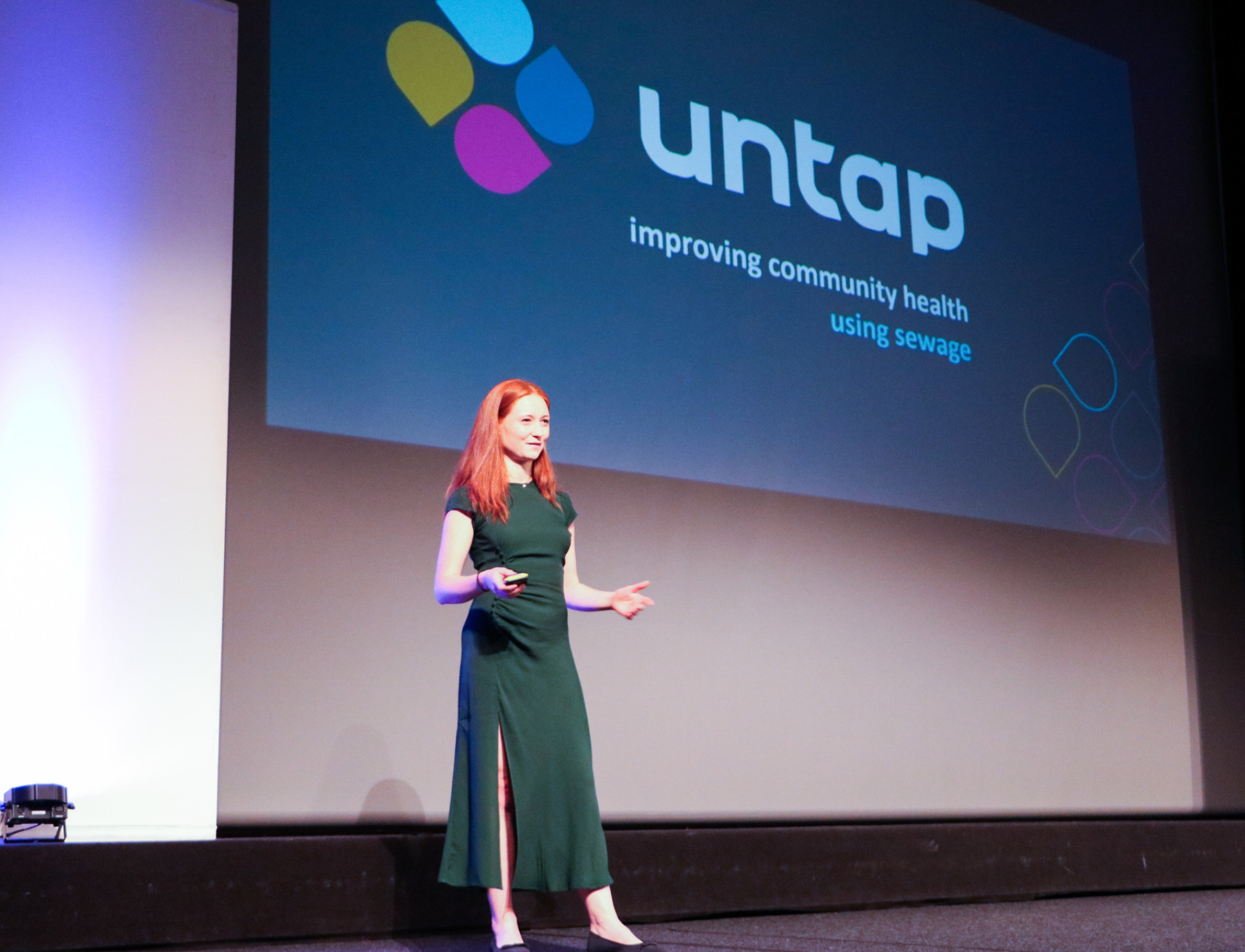 A woman in a green dress gives a presentation