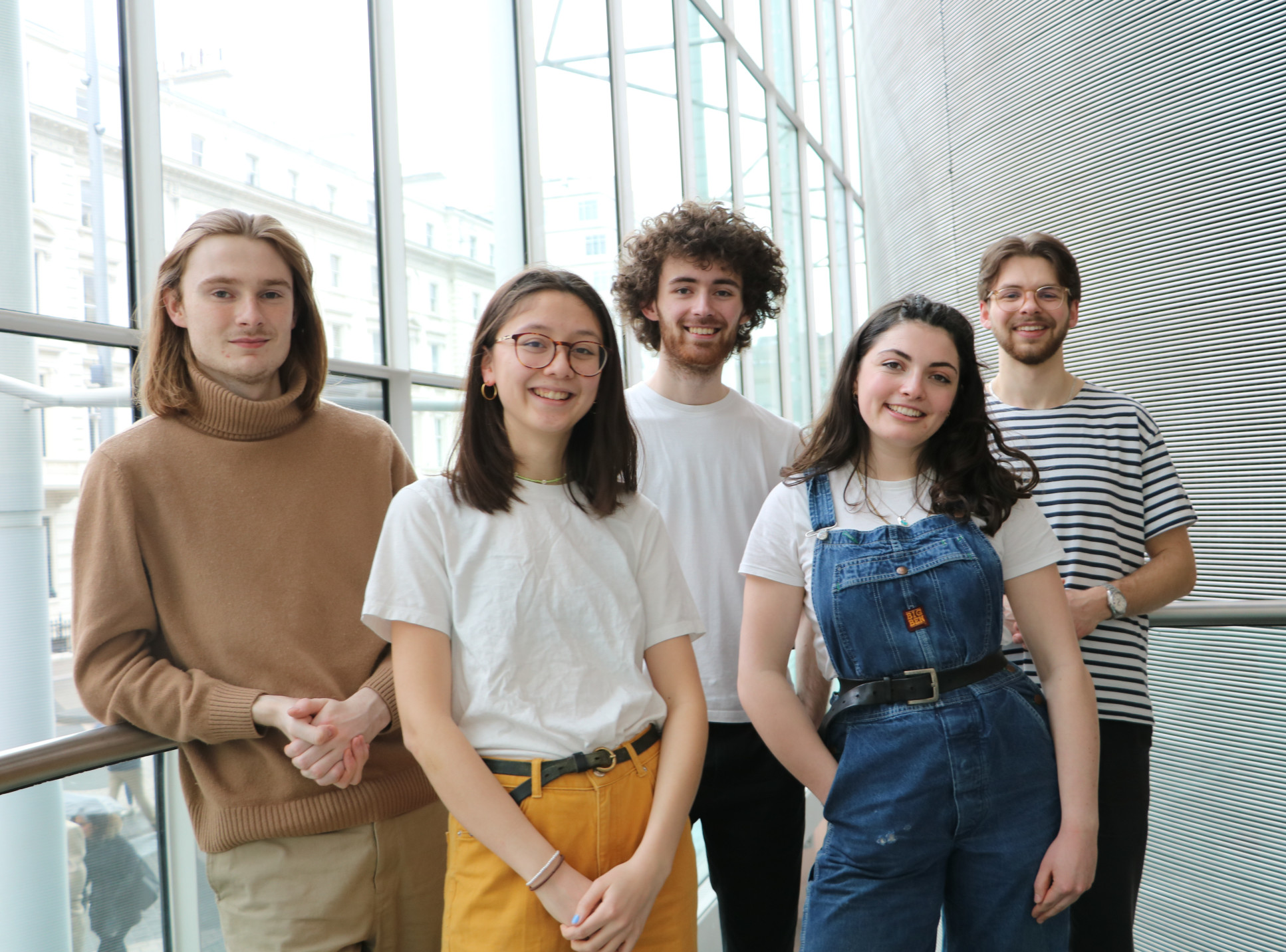 A group of five students stand together