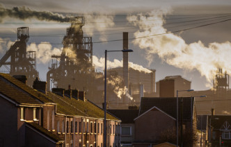 A row of houses with factory works in the background
