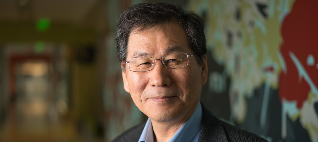 Man wearing glasses and a suit smiling at camera
