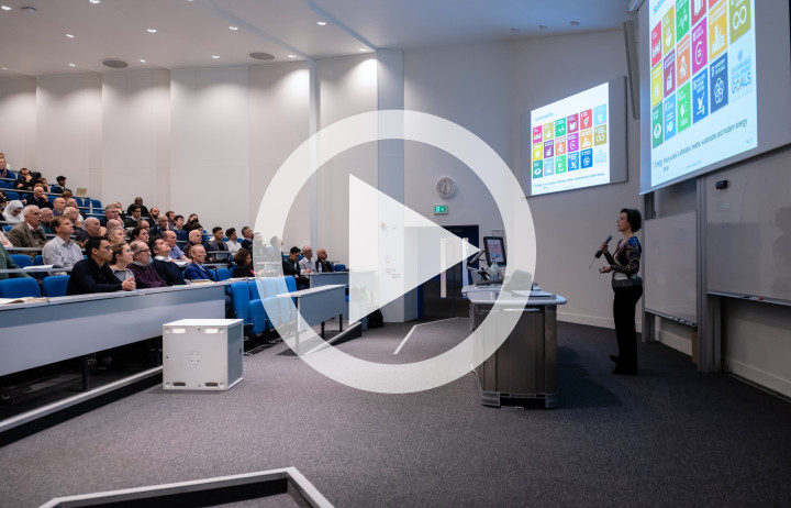 Lecture theatre with play button overlayed