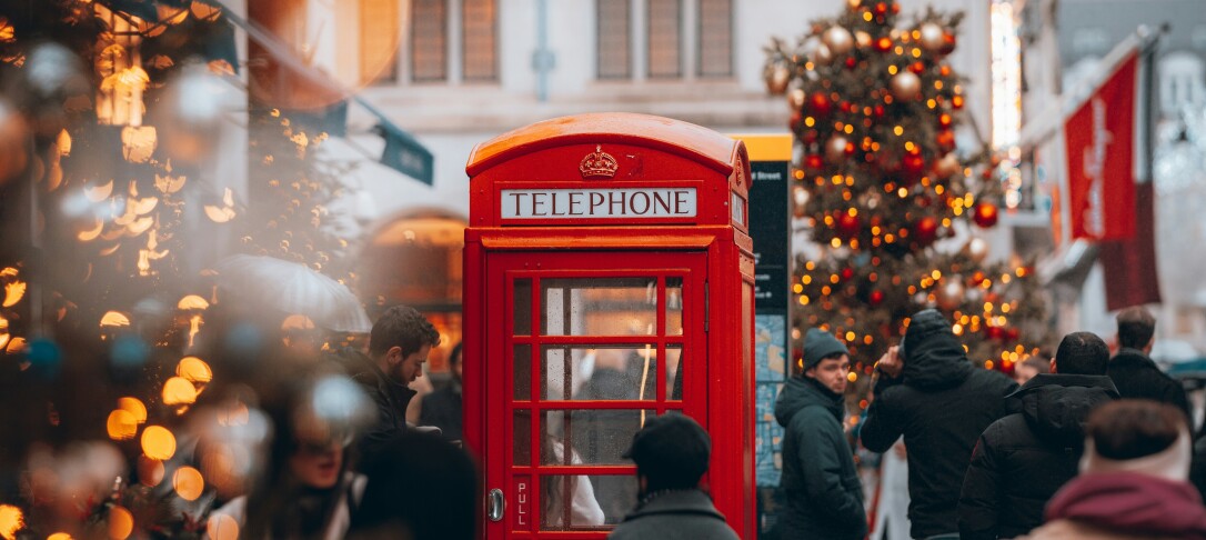 People walking amongst Christmas lights in London
