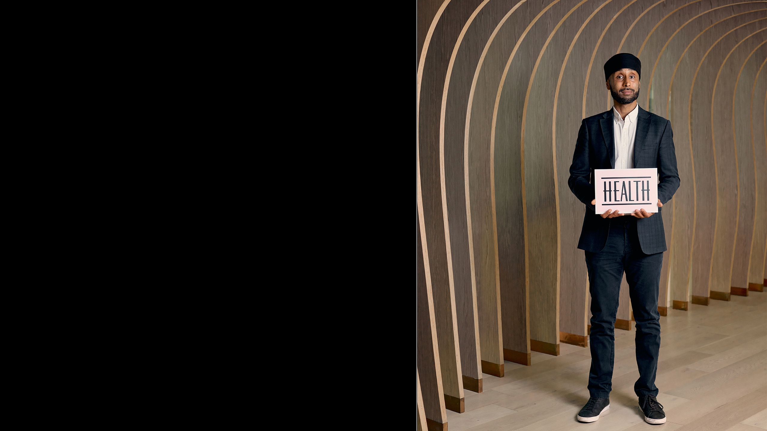 Arjun standing and holding a sign saying health