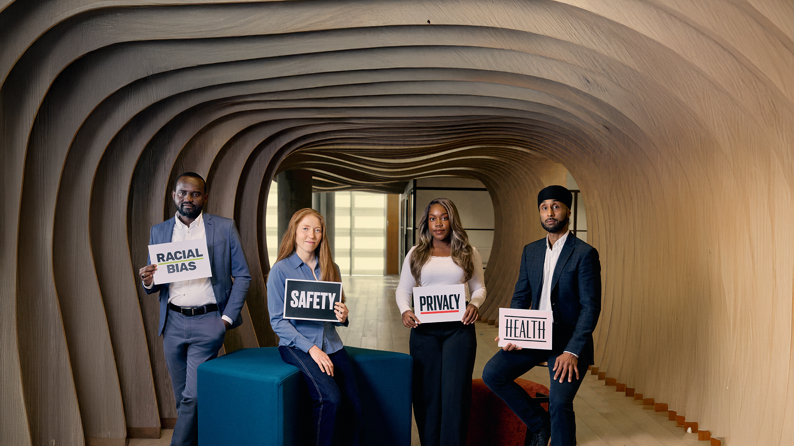 Four researchers holding signs covering what their research is about: racial bias, safety, privacy, health