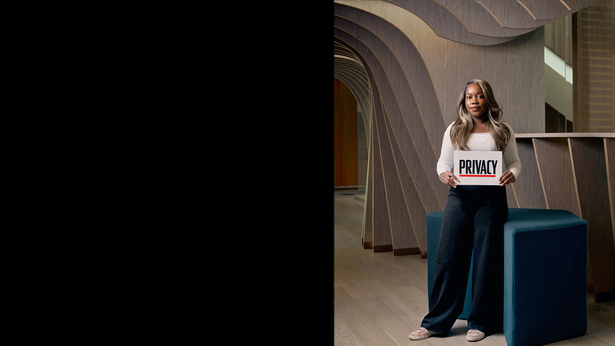 Euodia standing and holding a sign saying privacy