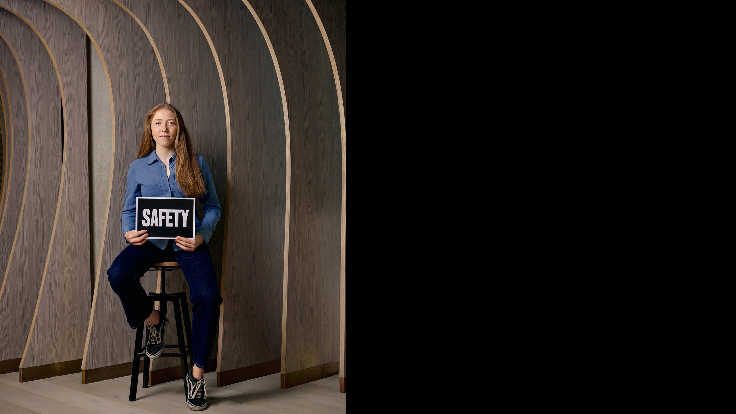 Anna sitting down and holding a sign saying safety