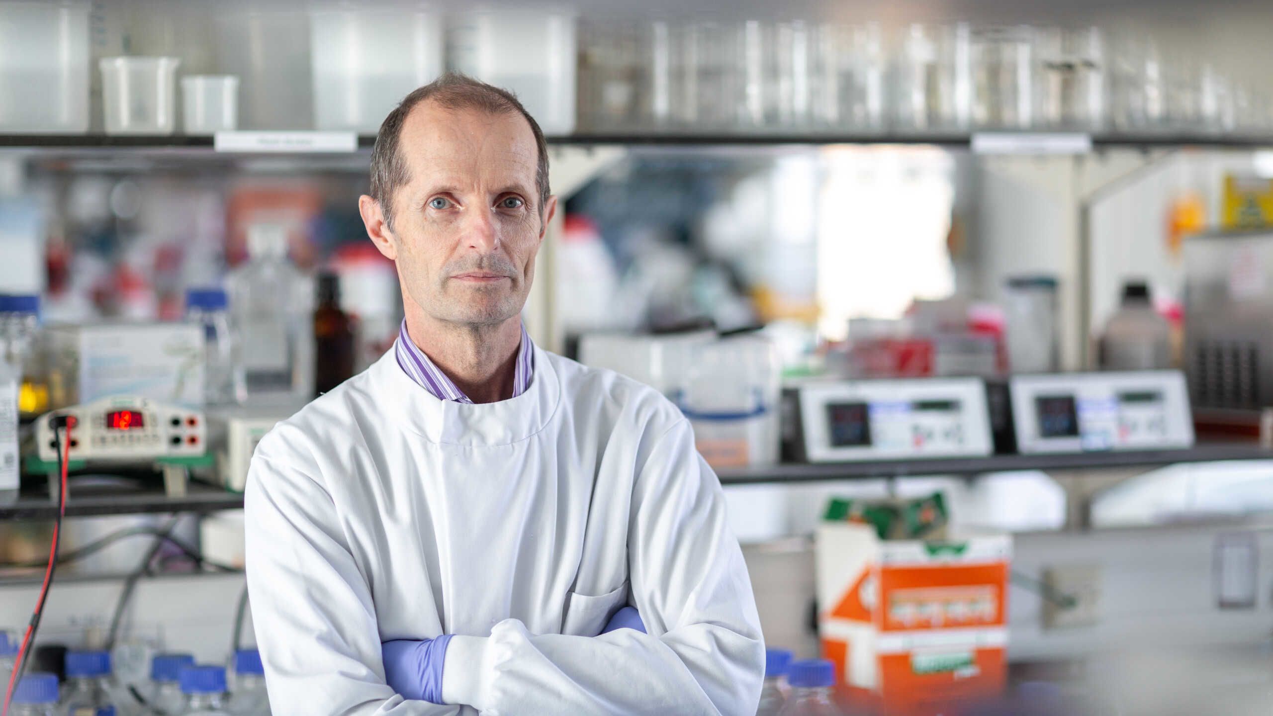 A photo of Professor Robin Shattock wearing a lab coat. Professor Shattock is the lead researcher for EAVI2020.