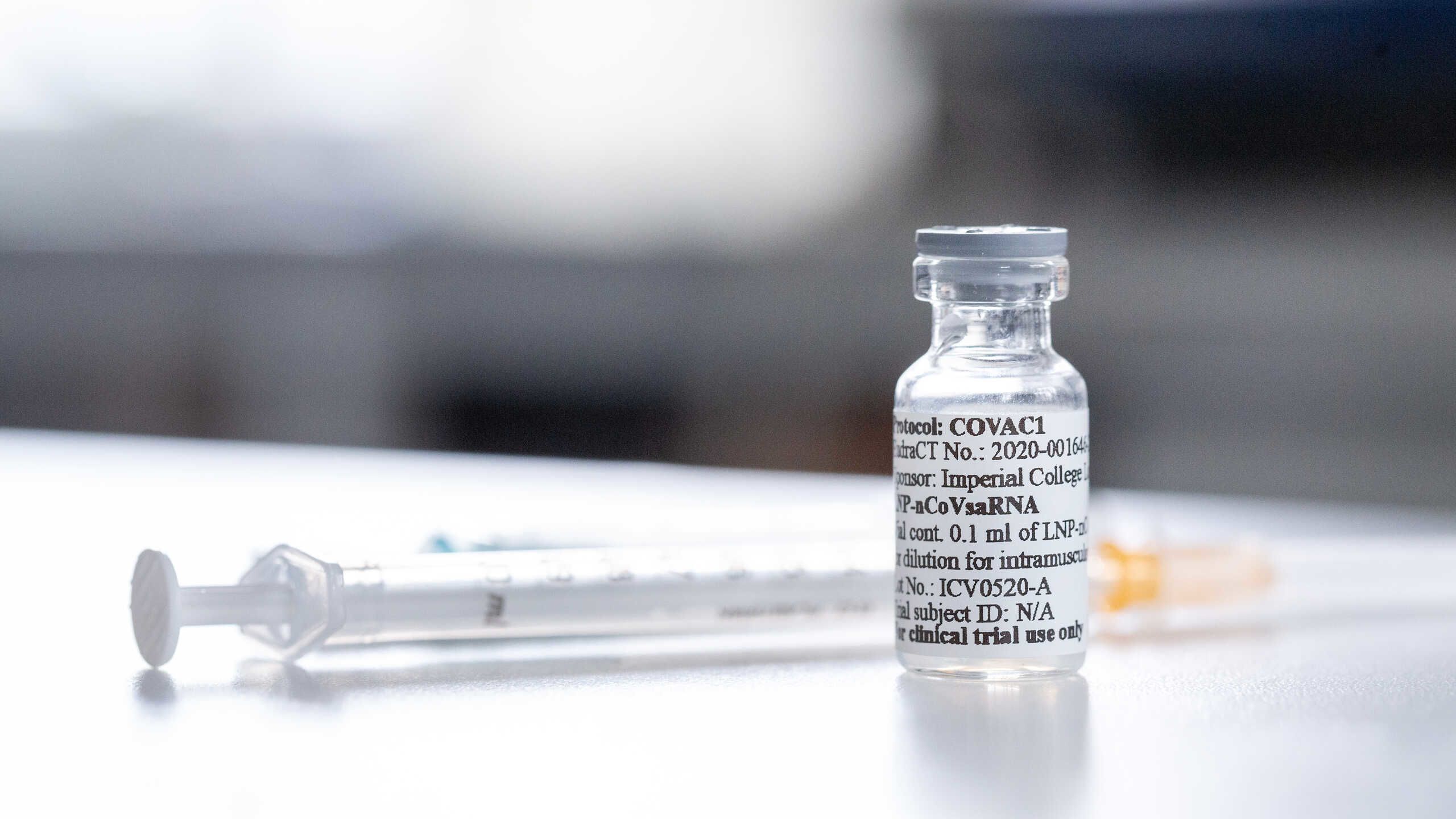 A photo of a syringe next to a COVID-19 vaccine candidate.