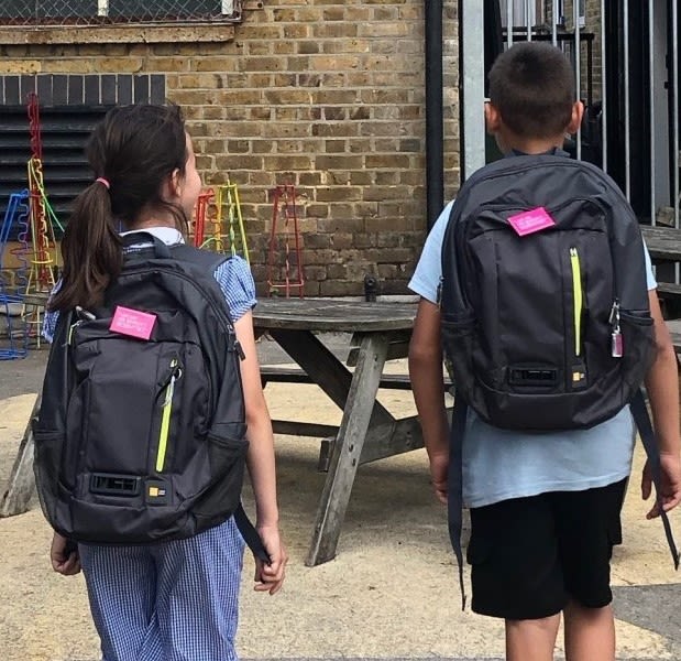Backs of children wearing backpacks