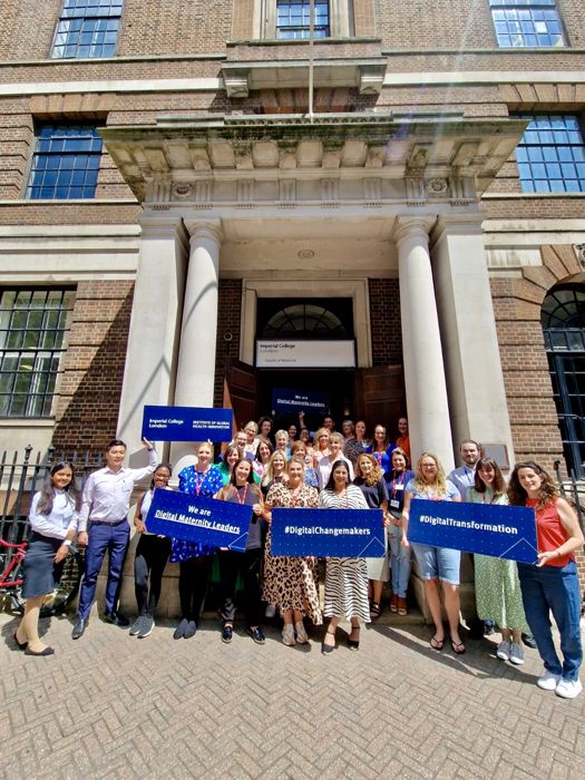 Students stand outside with banners that say "We are digital maternity leaders"
