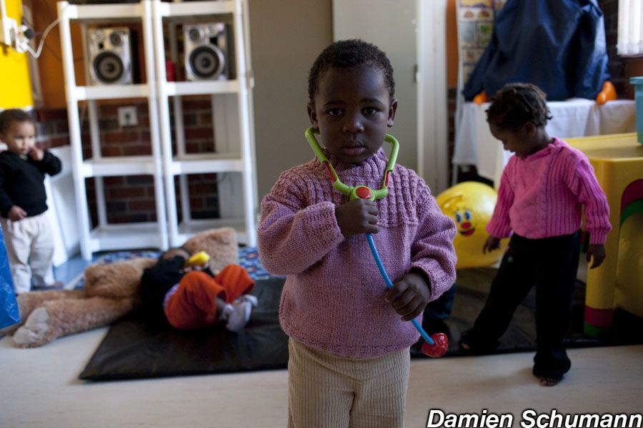 An outdoor meeting in Burkina Faso - a seated crowd listen to two women