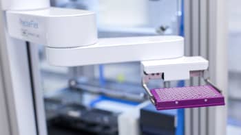 An automated robotic system carrying a microplate of DNA samples.
