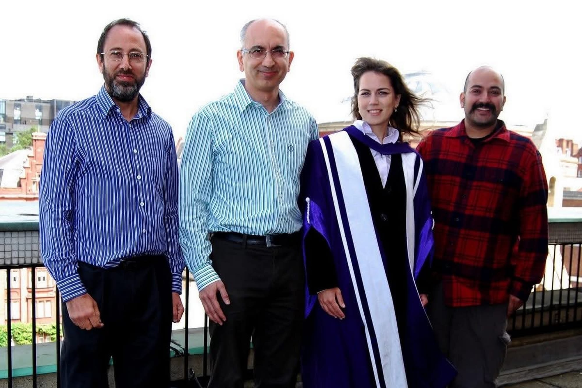 A group of four stood outside with Ibolya wearing graduation robes
