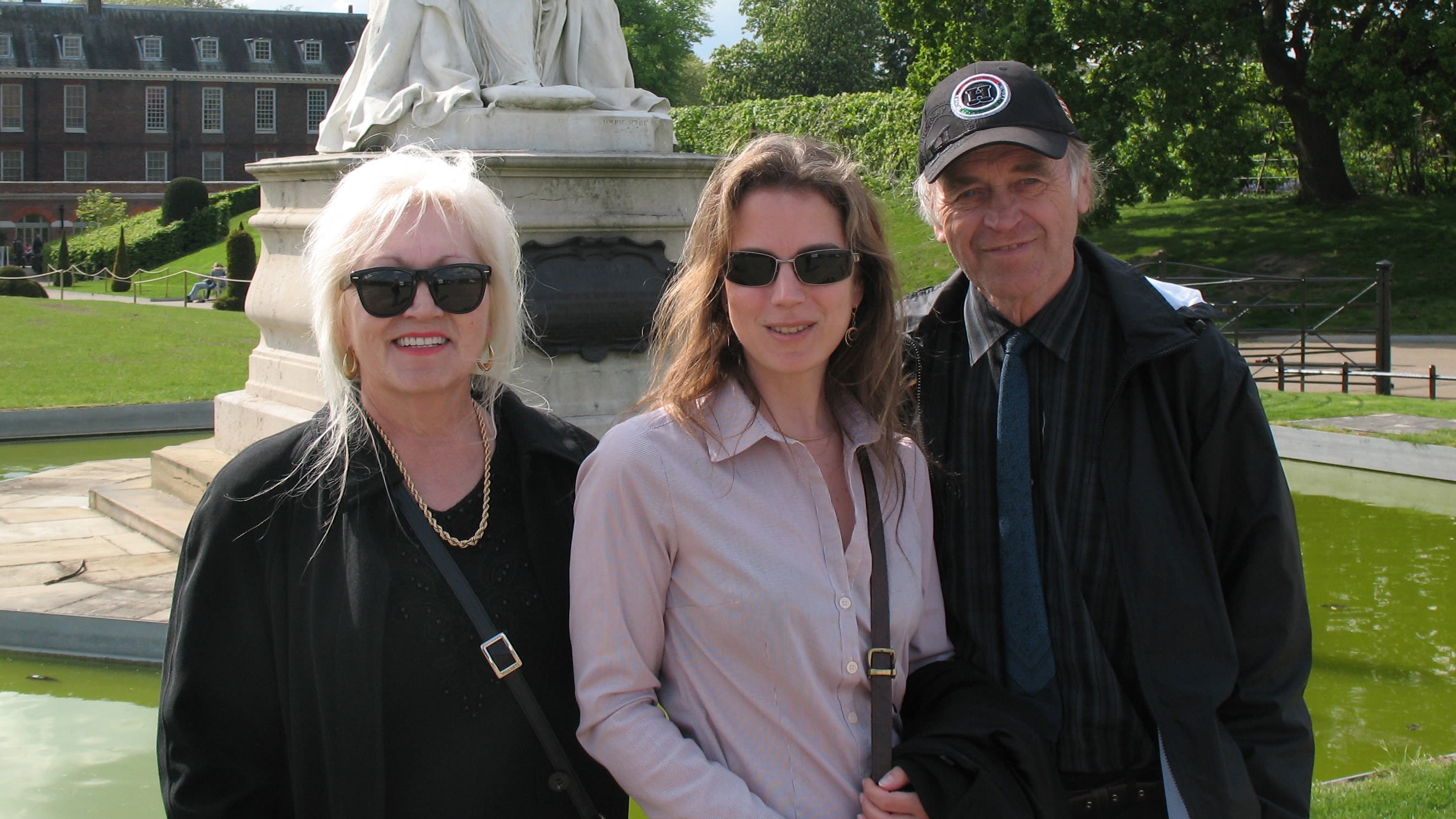 Ibolya flanked by her parents stood outside in front of a statue
