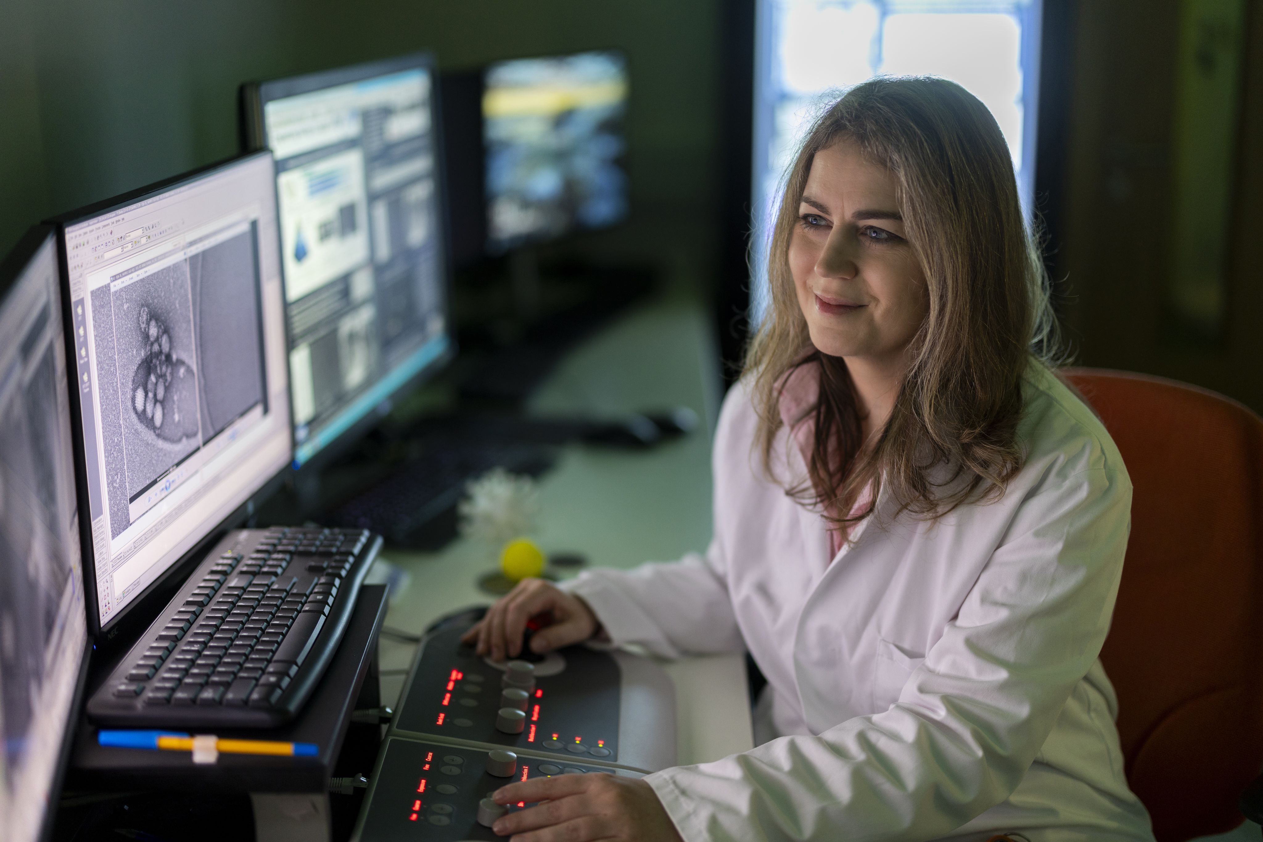 Ibolya Kepiro sat at a computer in a lab coat