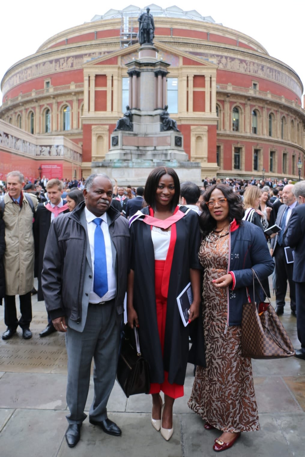 Jade stood outside the Royal Albert Hall wearing graduation robes with her mother and father