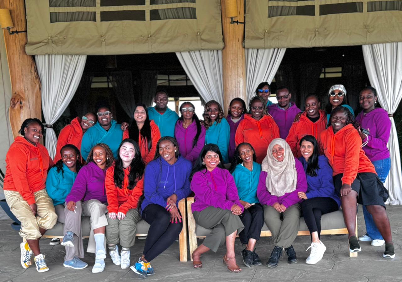 A group photo with people wearing matching colourful hoodies