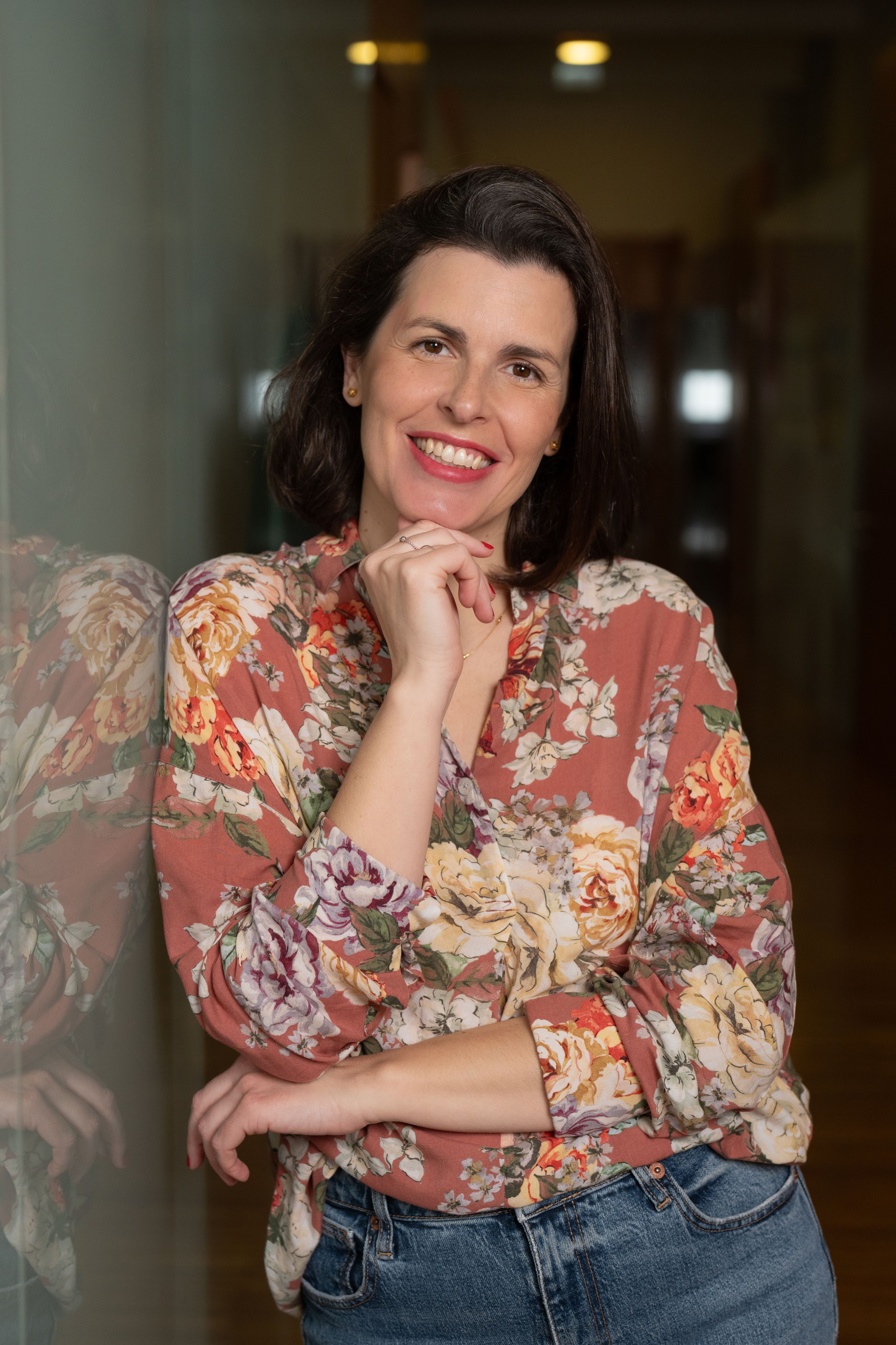 Joana Moscoso smiling wearing a floral blouse