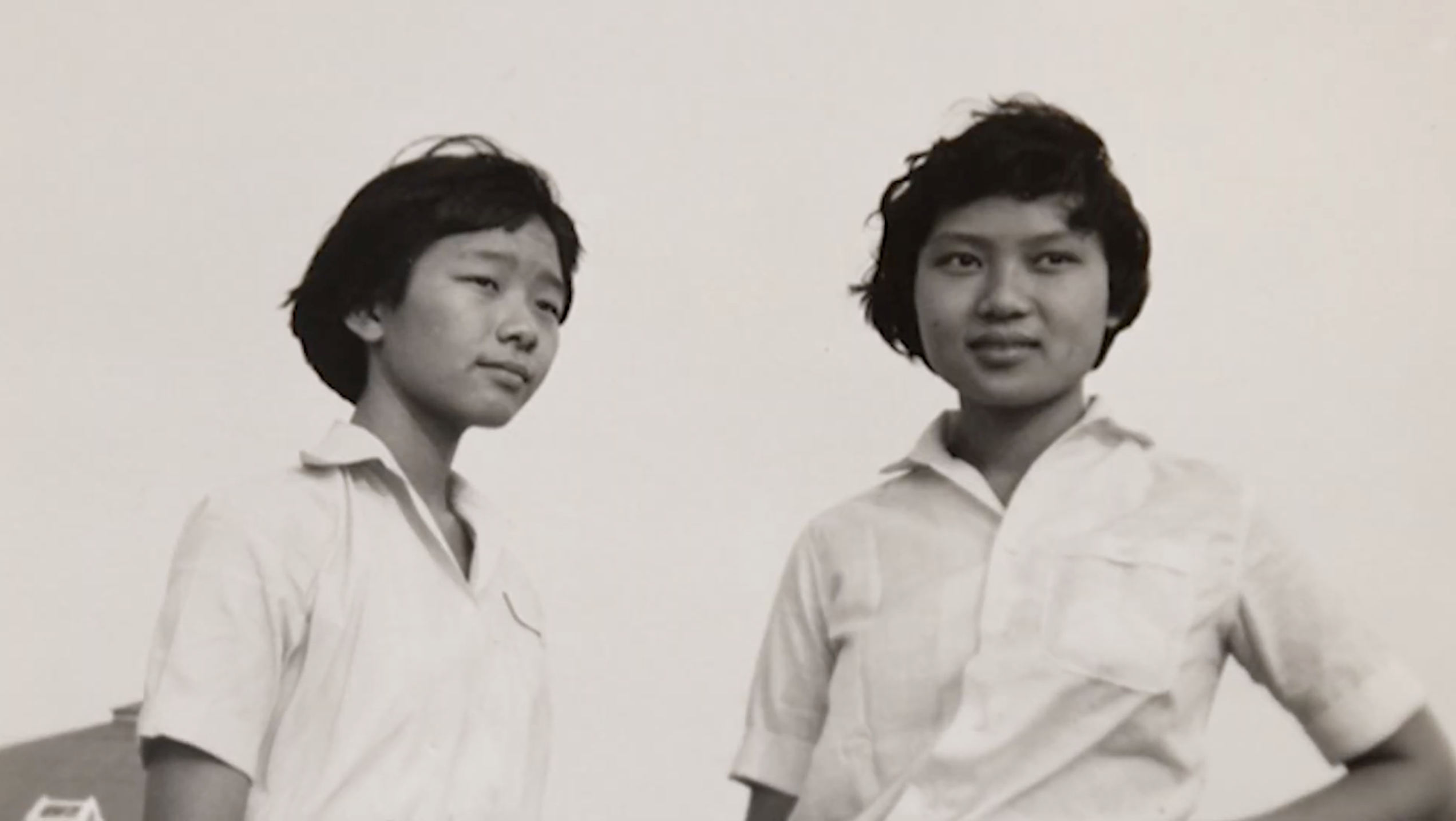 A black and white photo of two Thai girls in school shirts