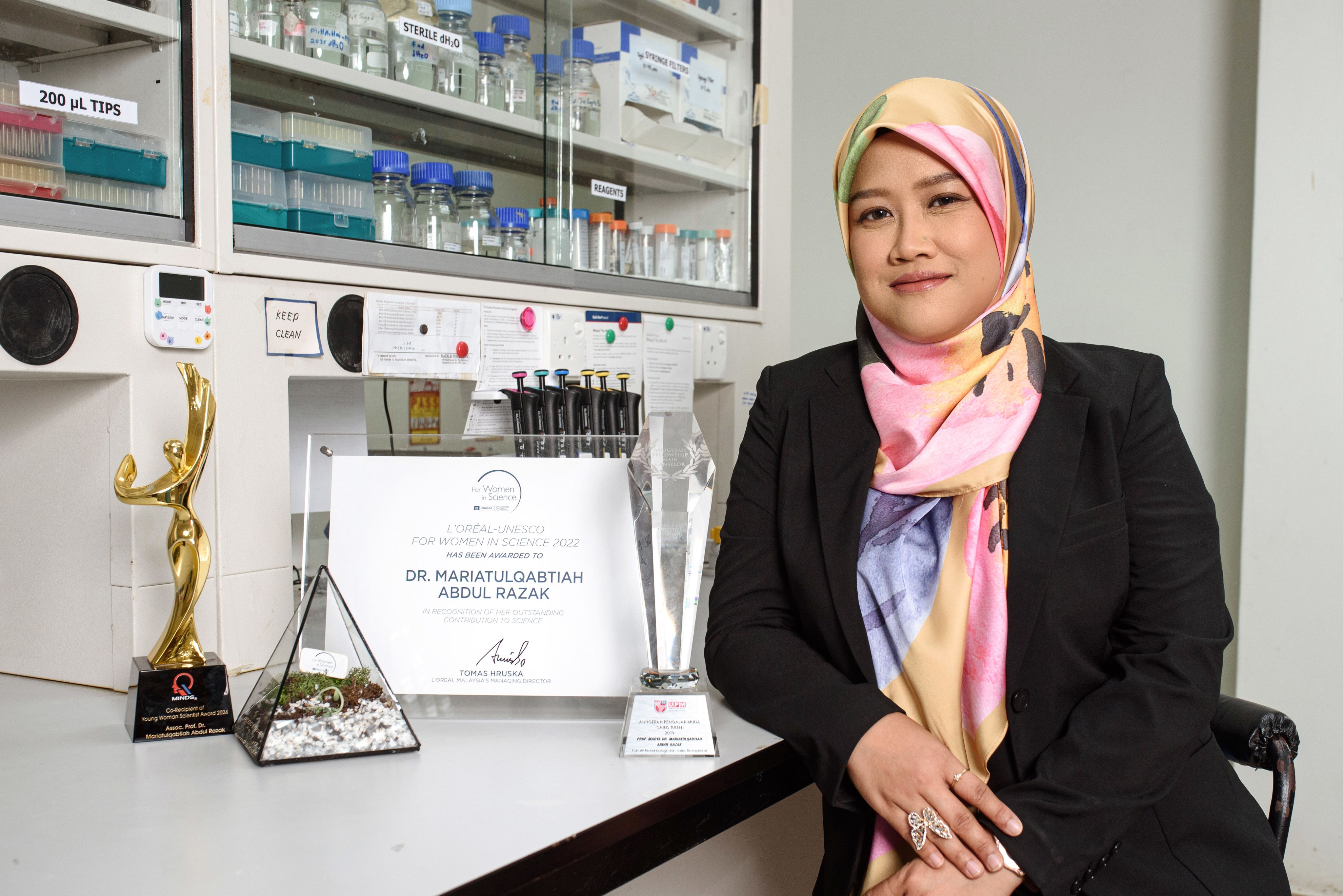 Dr Mariatulqabtiah Abdul Razak in her lab wearing a floral headscarf