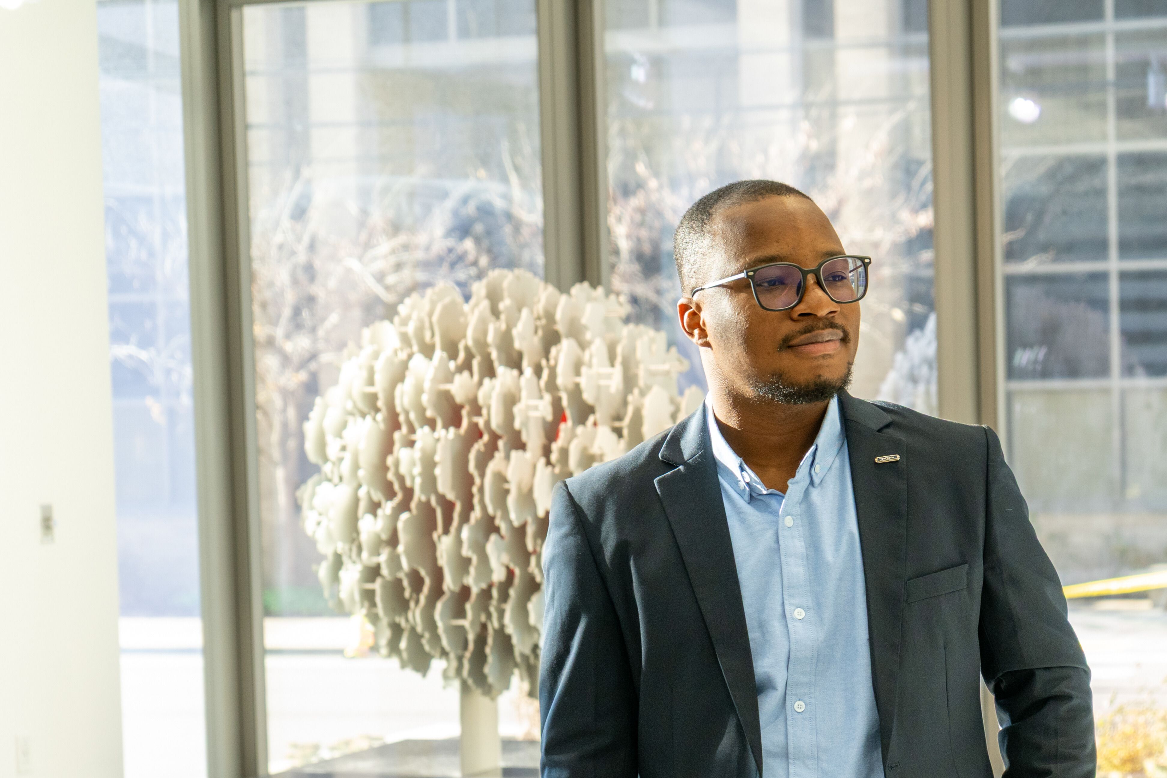 Tunde Oyebamiji wearing a suit and glasses