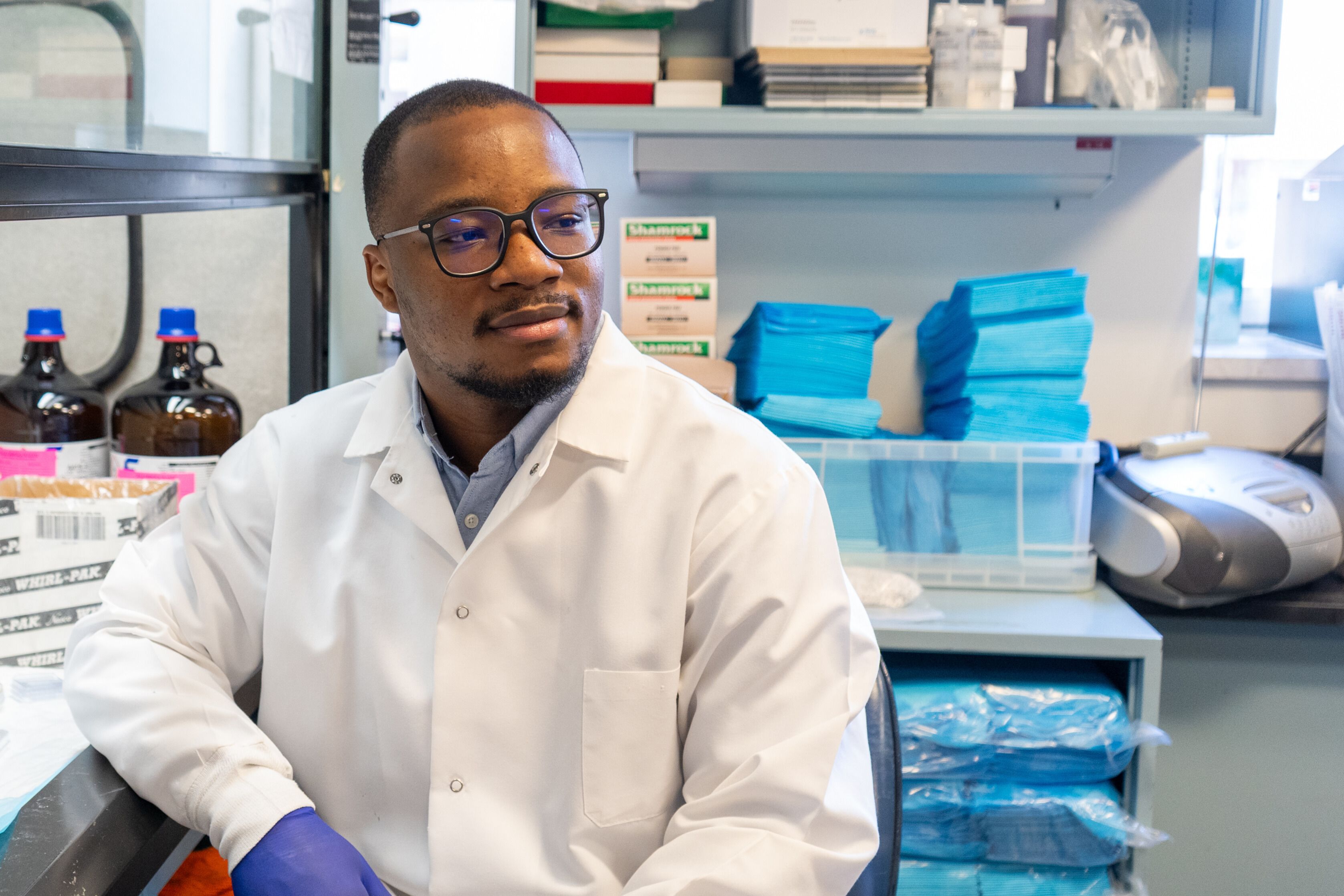 Tunde Oyebamiji in his lab wearing a lab coat