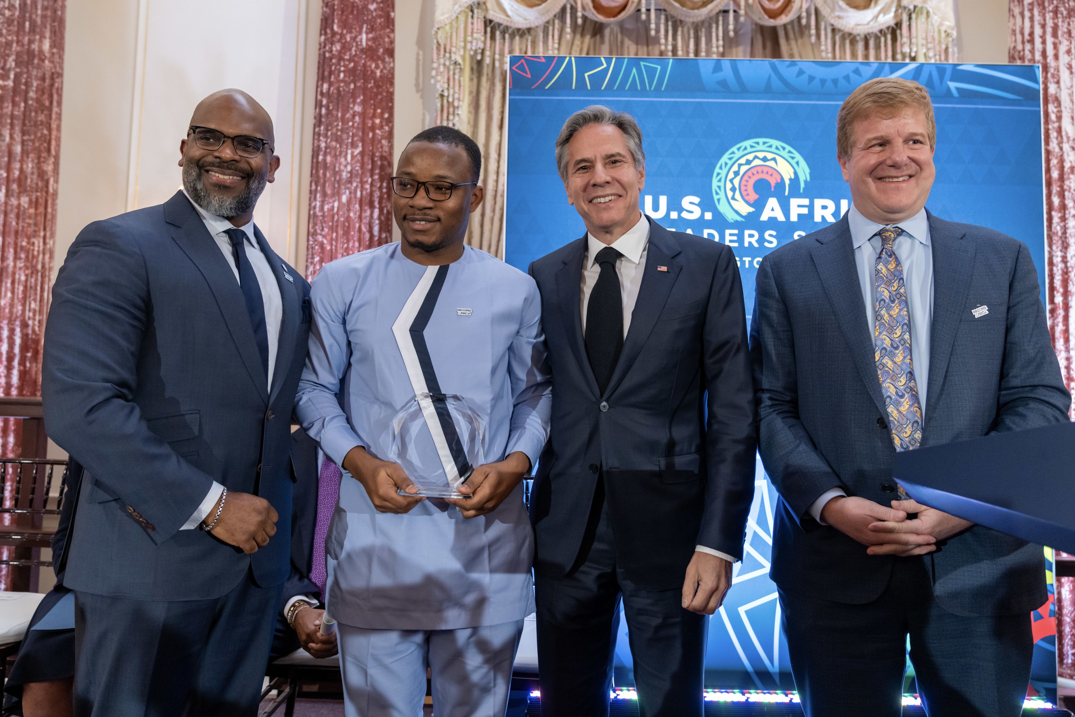 A group of four men in suits