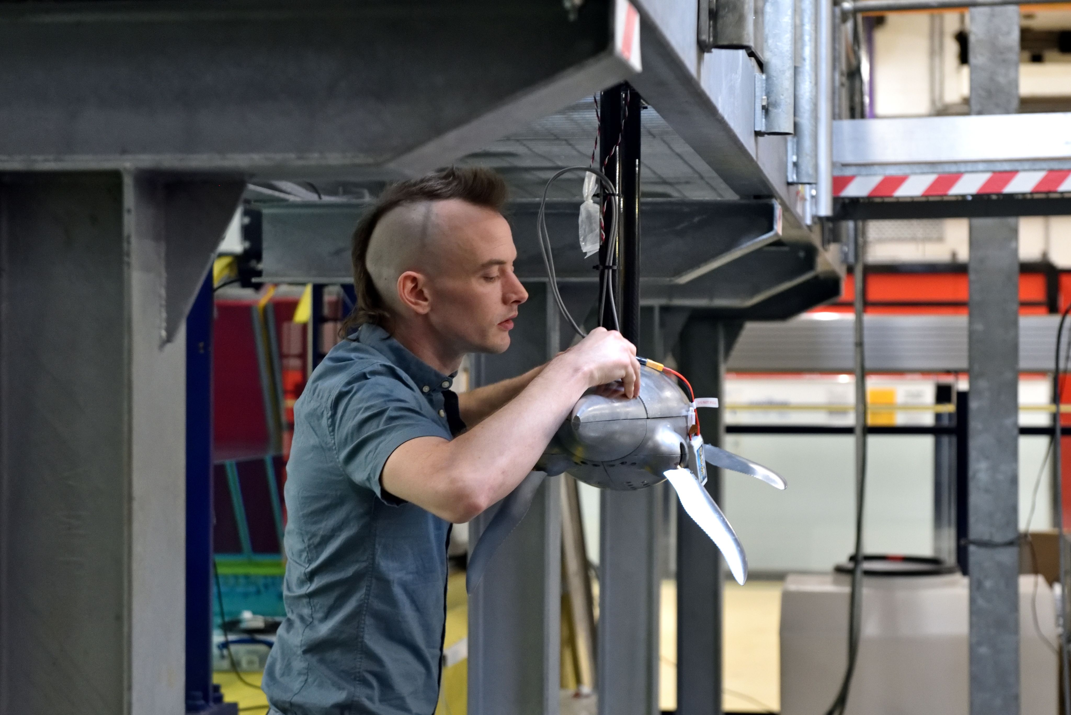 Photo of Luke assembling the robot in front of the wave tank