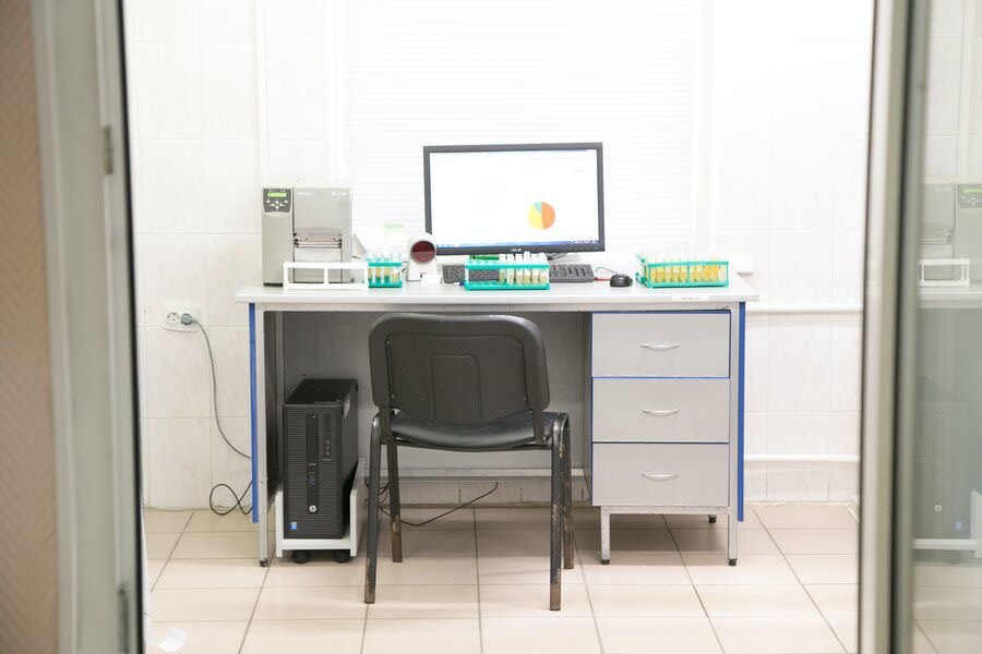 a desk with a computer and a chair